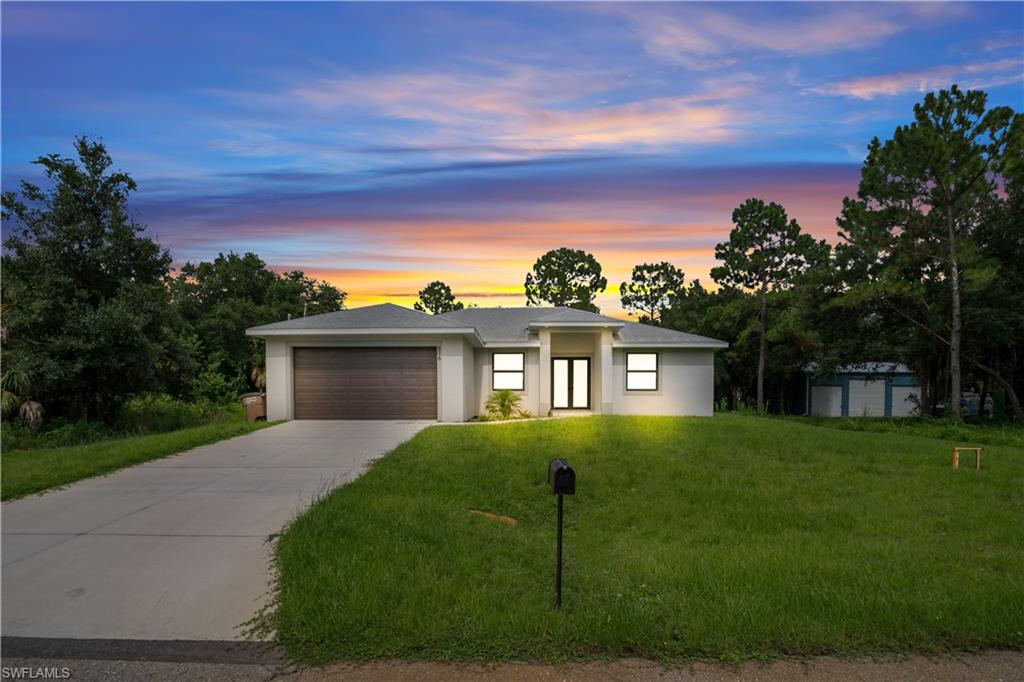 Contemporary single-story residence featuring a wood-finish garage door and a concrete driveway