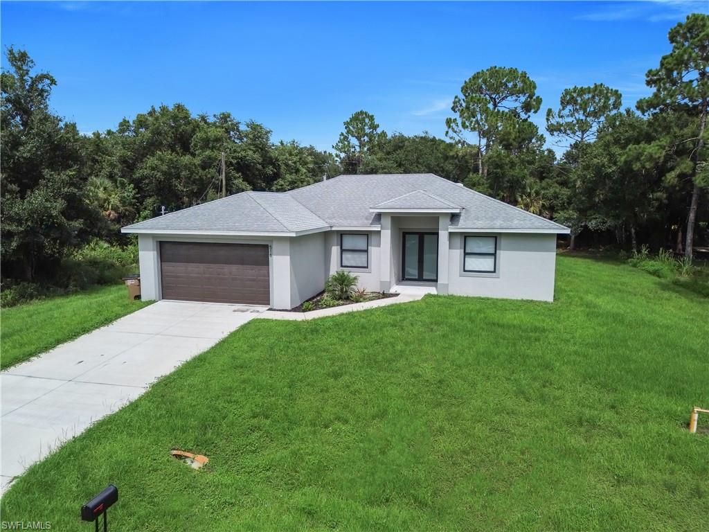 Contemporary single-story residence with a gray exterior finish and a dark wood-finish garage door