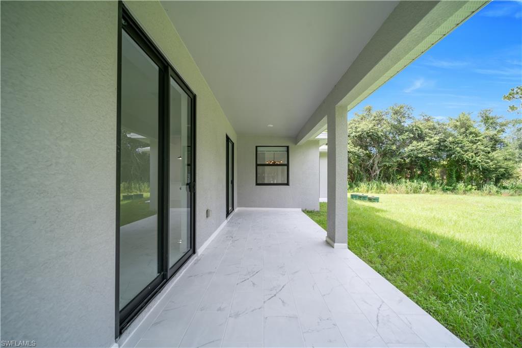 Covered patio with large-format white tile flooring, offering expansive outdoor living space