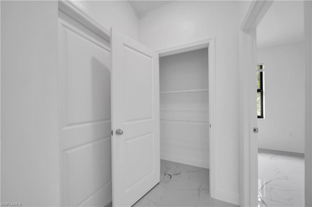 Interior hallway featuring a storage closet with wire shelving and a separate room entrance