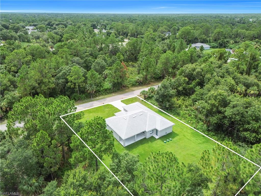 Aerial view of a contemporary residence featuring a light-colored exterior and a gray hip roof