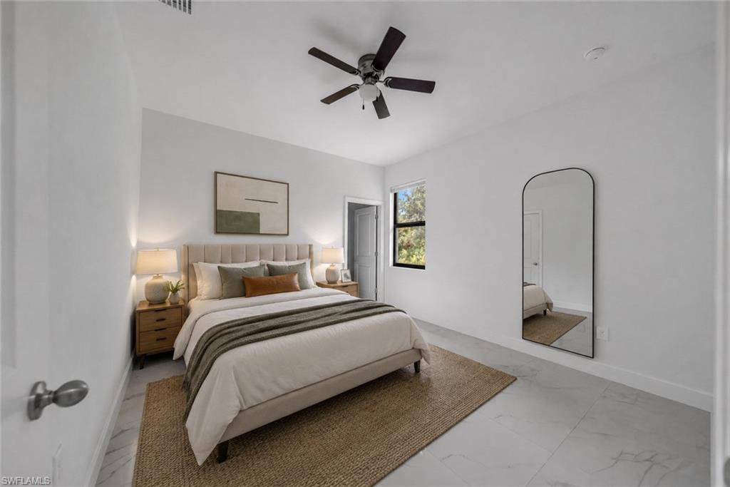 Bedroom featuring light tile flooring, a dark ceiling fan, a window with exterior views, and a white interior door