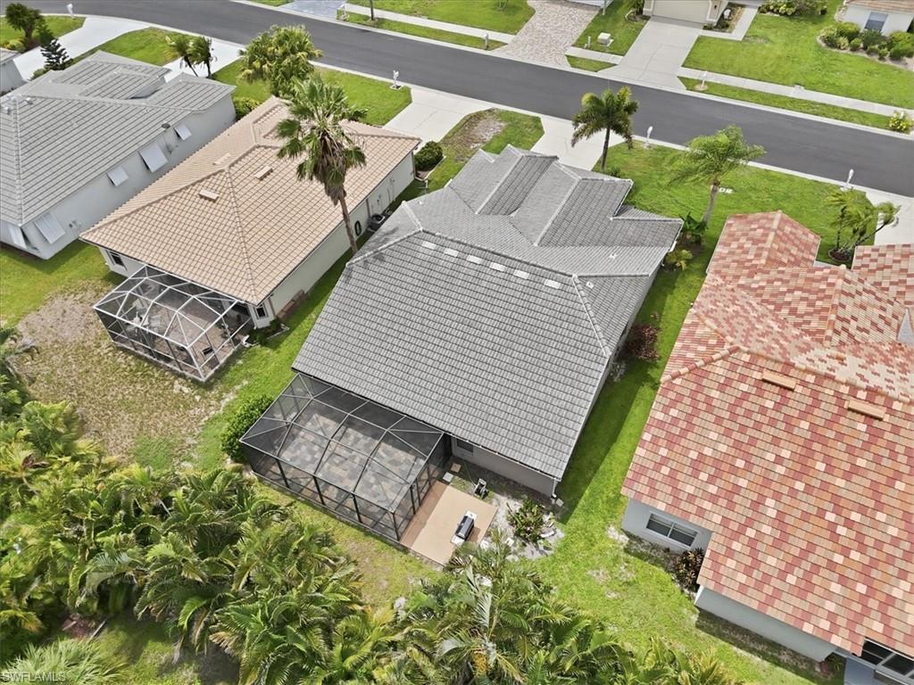 Aerial perspective showcasing a property with a grey tile roof and an enclosed screened patio