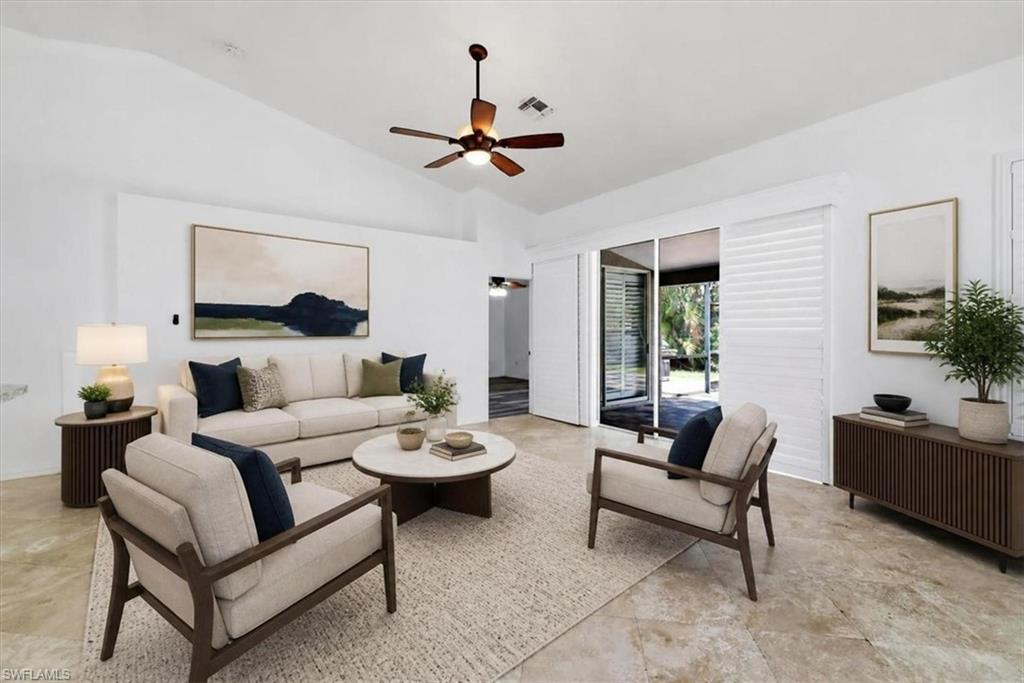 Spacious living area featuring vaulted ceilings and textured stone flooring