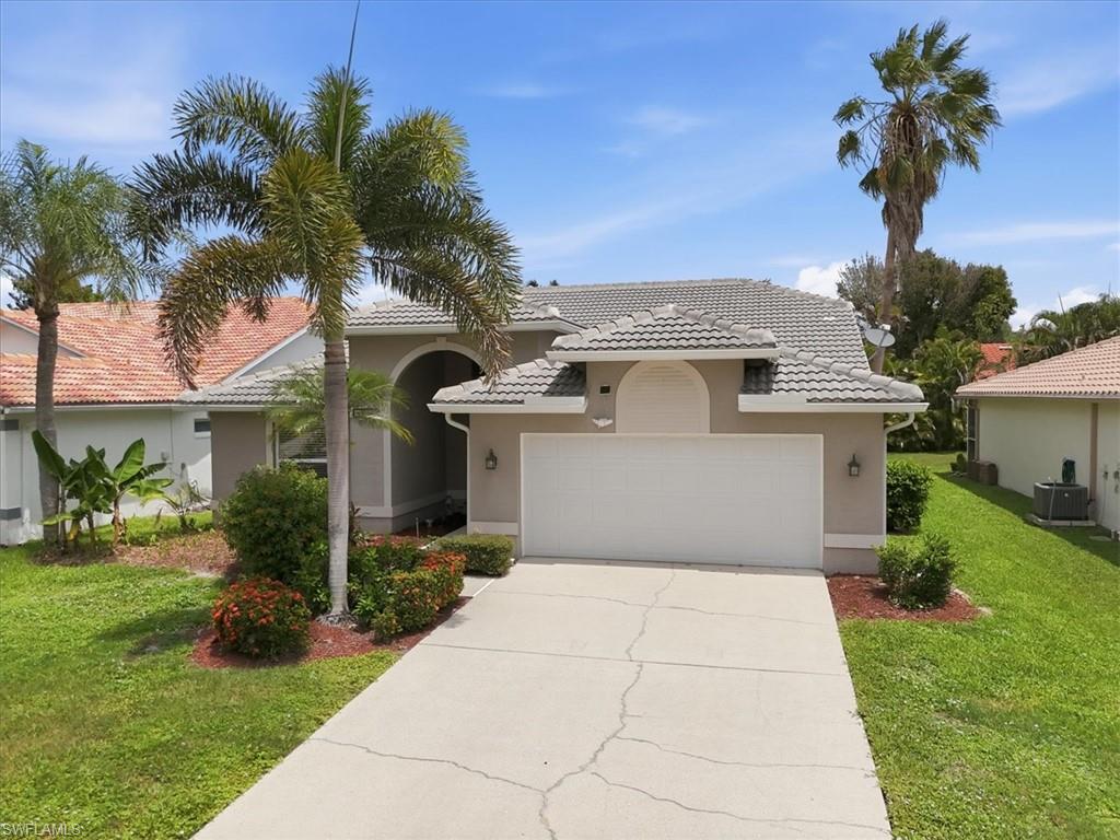Single-story residence featuring a tile roof, arched entry, and a two-car garage