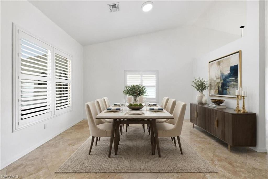 Vaulted ceiling dining area featuring plantation shutters, neutral wall tones, and large format tile flooring