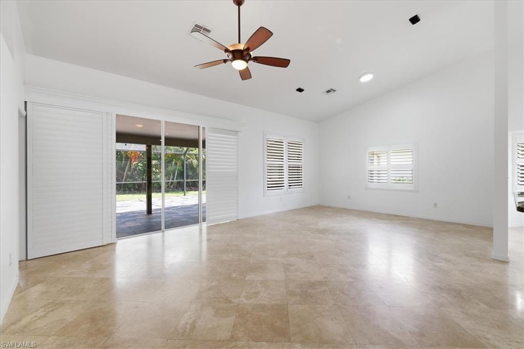 Expansive interior space featuring a vaulted ceiling and light-toned tile flooring