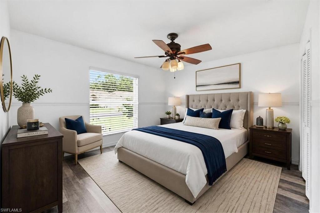 Bright interior featuring wood-finish flooring, a ceiling fan with light kit, and a large window with horizontal blinds