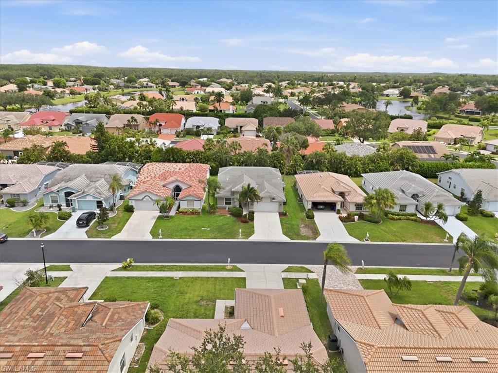 Residential neighborhood featuring a variety of single-story homes with tile roofs, paved driveways, and manicured lawns