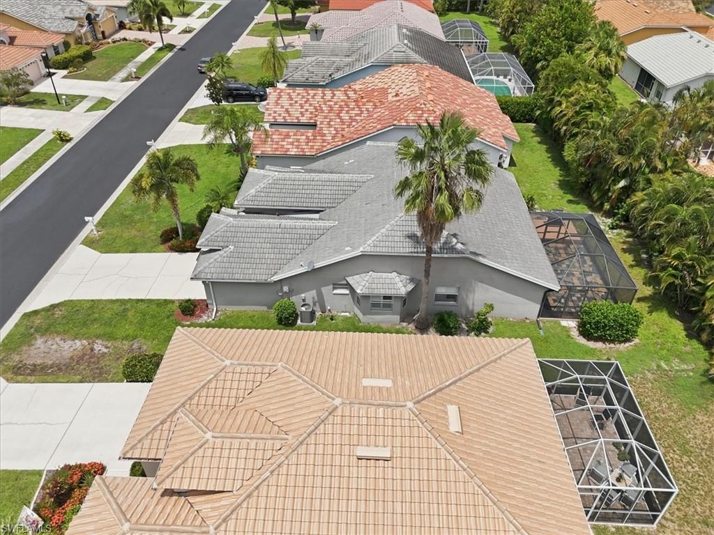 Aerial view showcasing a residential property with a screened lanai and mature landscaping