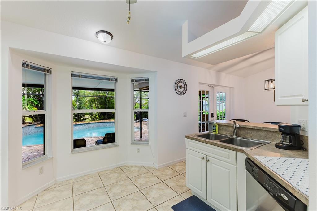 Kitchen area with bay windows overlooking a swimming pool and patio