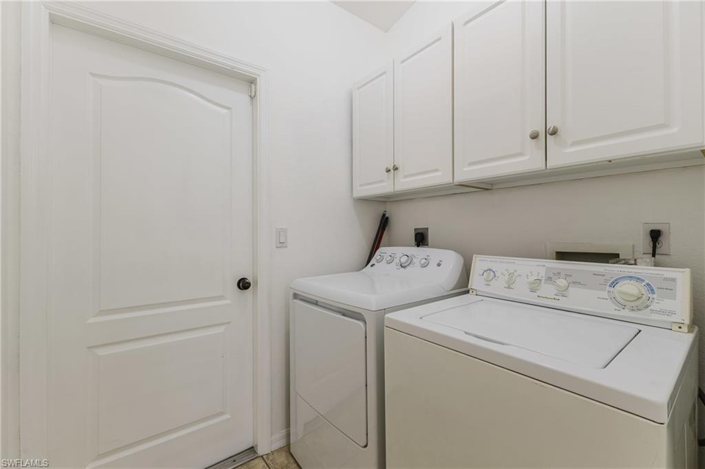 Dedicated laundry area featuring white cabinetry, a built-in shelf, and a panel door