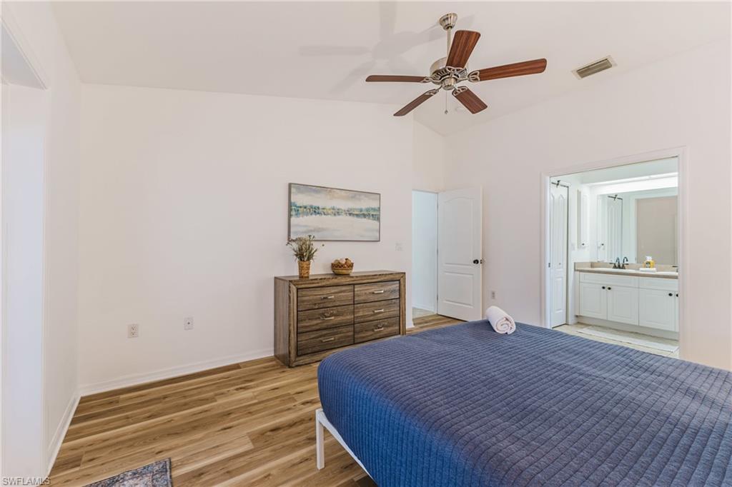 Bedroom featuring vaulted ceilings, wood plank LVP flooring, and a ceiling fan