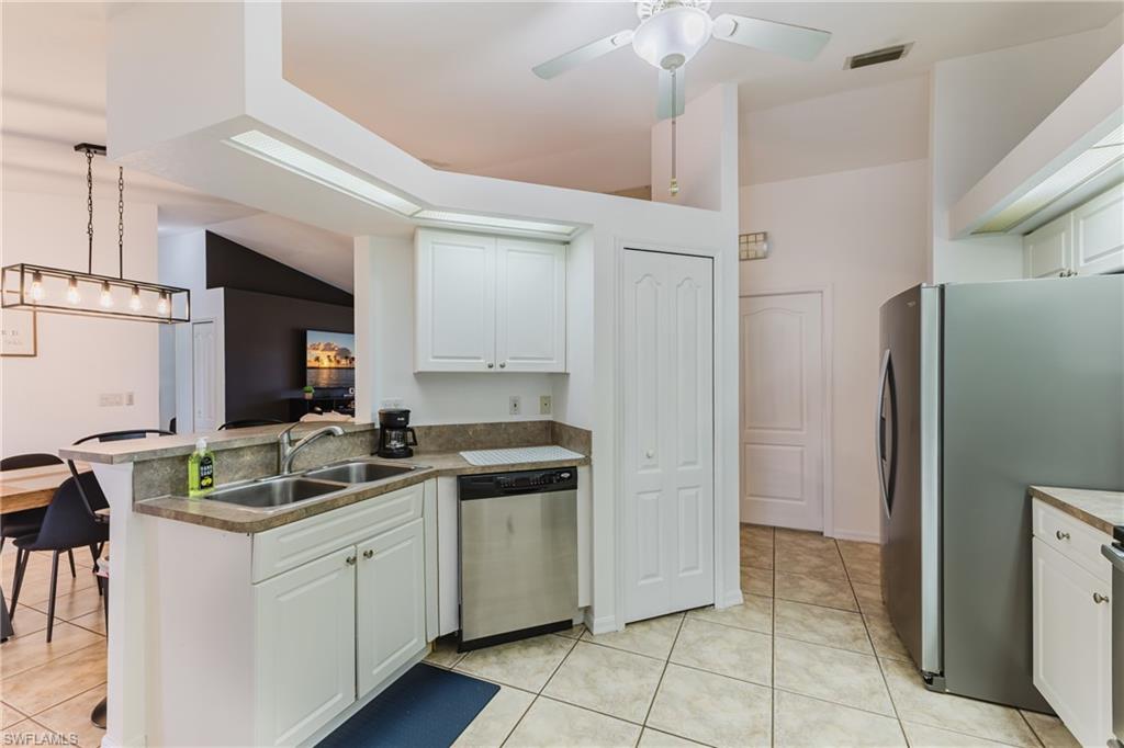 Kitchen featuring white cabinetry, a double basin stainless steel sink, and a stainless steel dishwasher