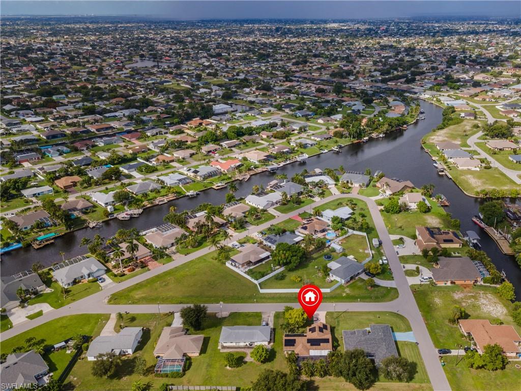 Aerial perspective of a residential neighborhood featuring canals and numerous single-story properties