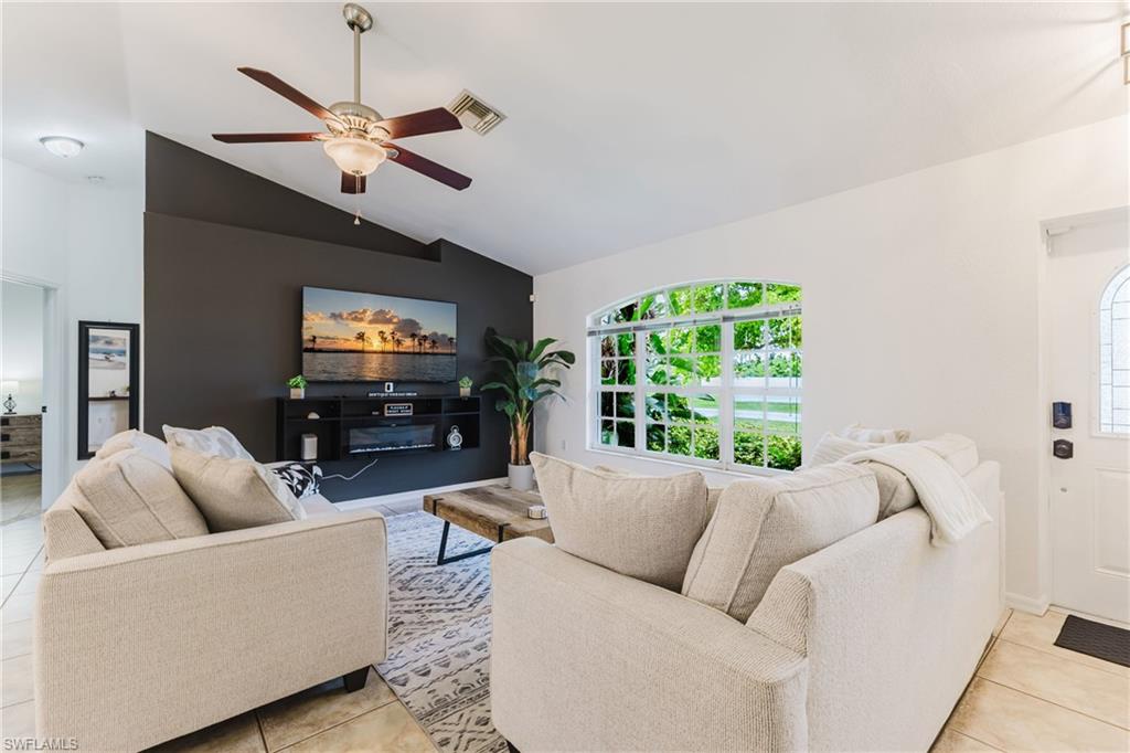 Living area featuring vaulted ceilings, a contemporary ceiling fan, and a built-in media console