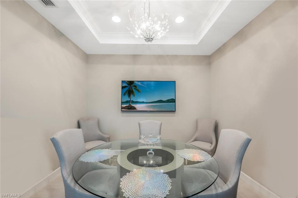 Recessed ceiling with crown molding and central chandelier lighting