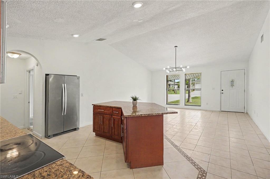 Kitchen island with granite countertop and rich wood-finish cabinetry