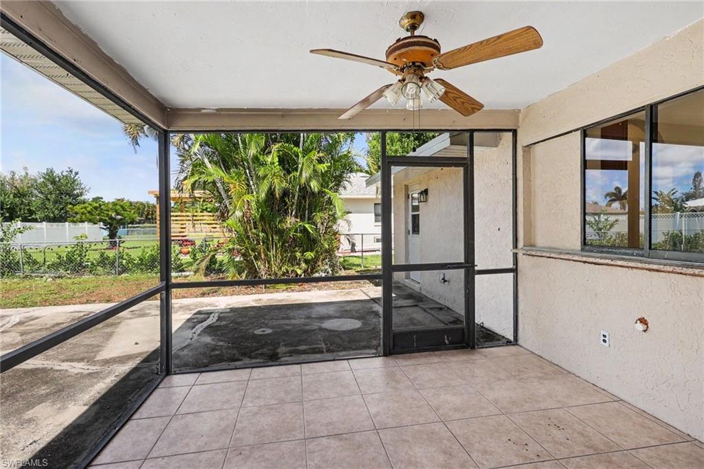 Screened patio featuring tile flooring and a ceiling fan with light fixture