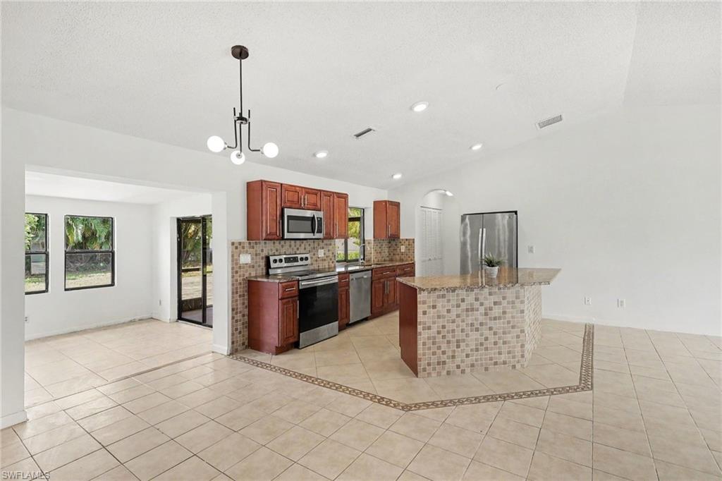Kitchen featuring wood cabinetry, stainless steel appliances, and a tiled backsplash