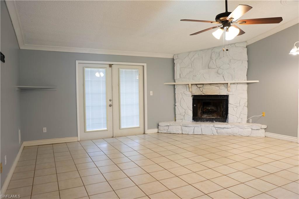 Living Room with Fireplace and French Doors leading to the Pool.