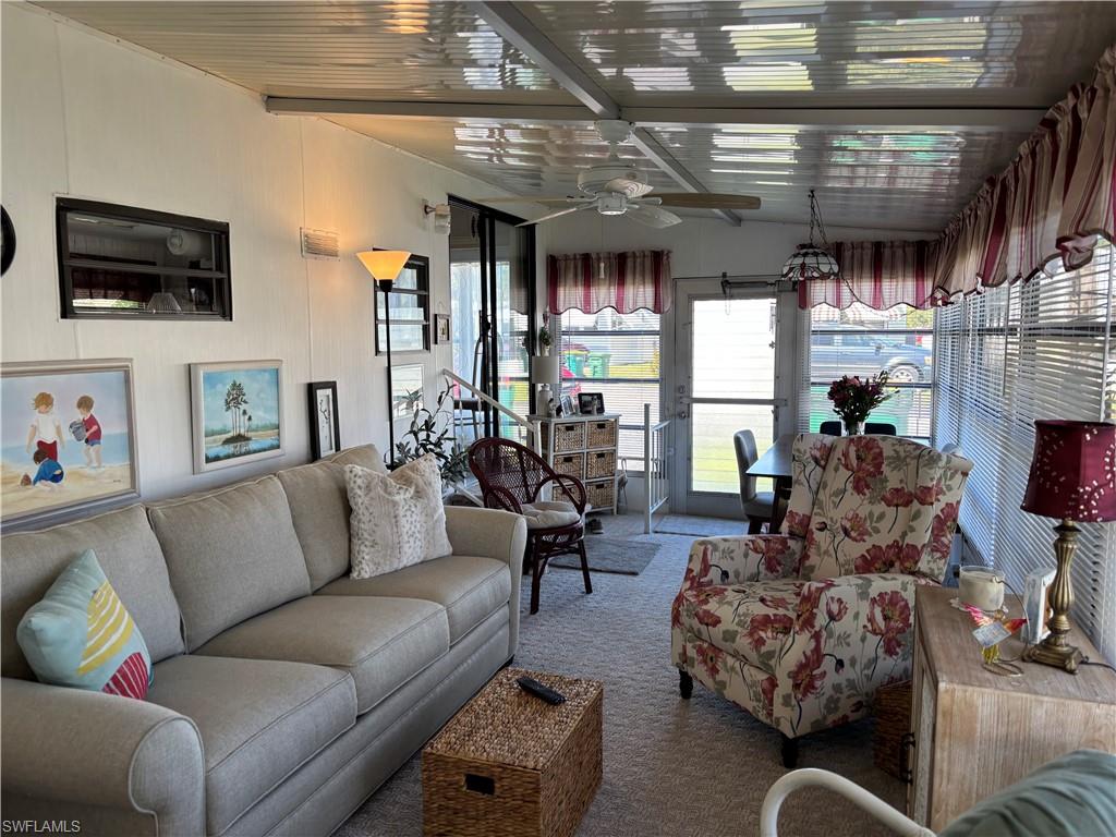 Living room featuring carpet and a ceiling fan