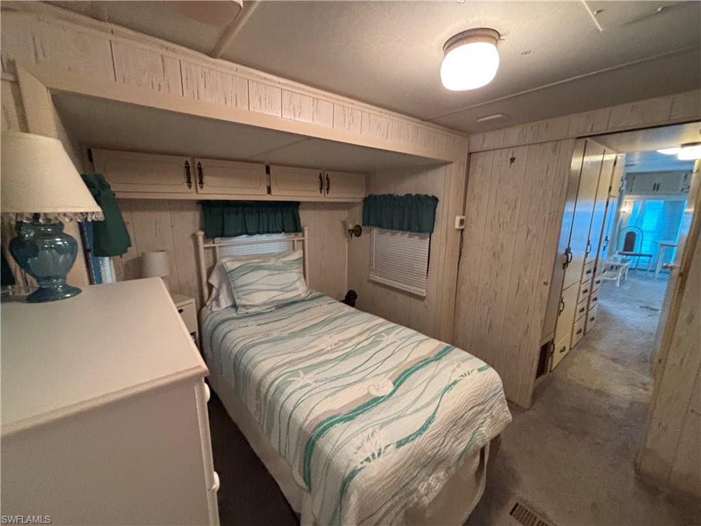 Built-in overhead cabinetry, white wood-paneled walls, white window blinds, and overhead globe lighting