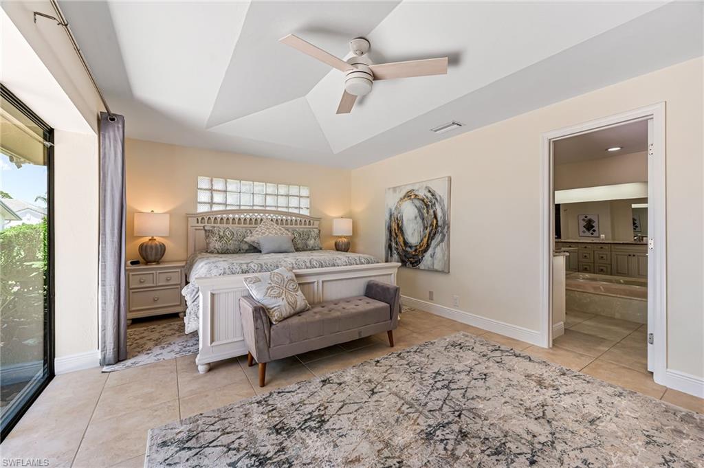 Bedroom featuring ensuite bathroom, multiple windows and walk in closet.