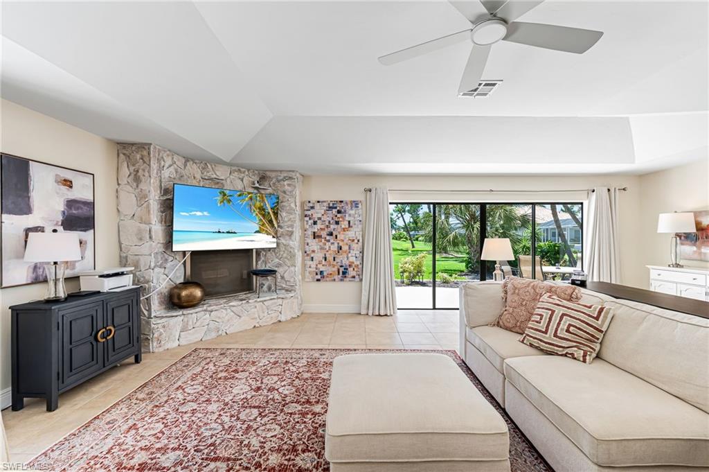 Living room featuring a fireplace raised ceiling, and light tile patterned floors