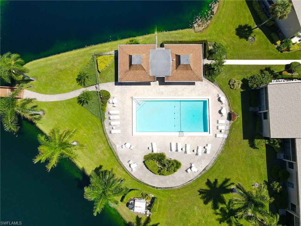 Clubhouse with a tiled roof, rectangular swimming pool, and surrounding concrete deck
