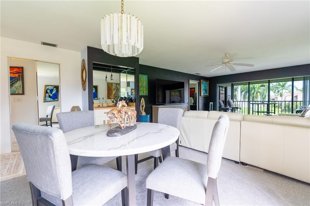 Open-concept living space with a contemporary chandelier and a marble-finish dining table