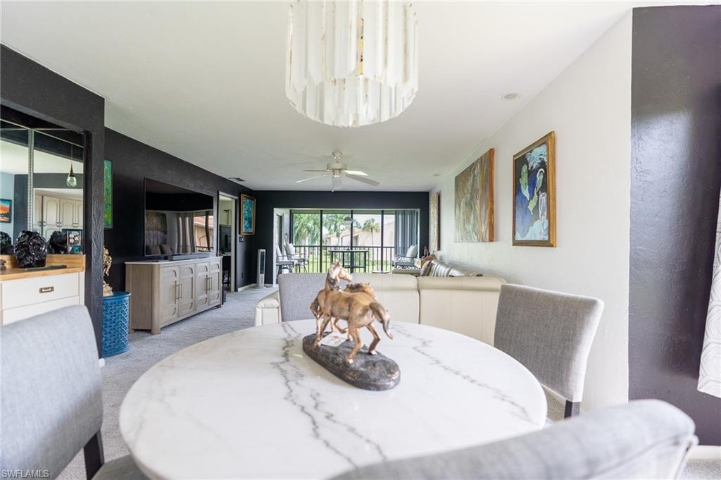 Dining area featuring a round white marble-look table and a contemporary chandelier