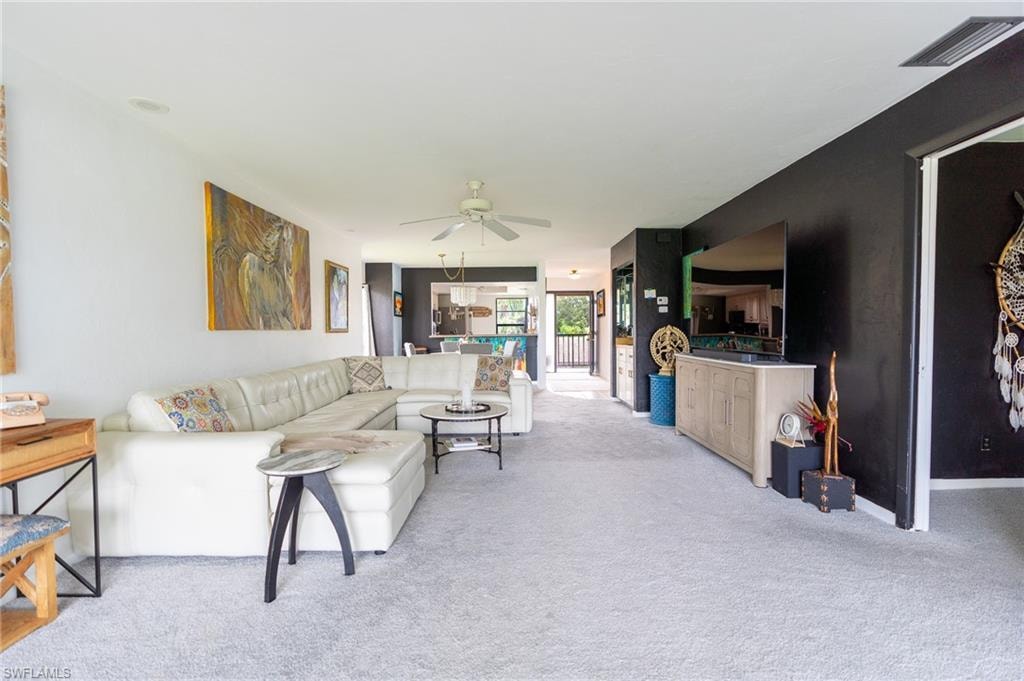 Spacious interior featuring light gray carpeting and a ceiling fan