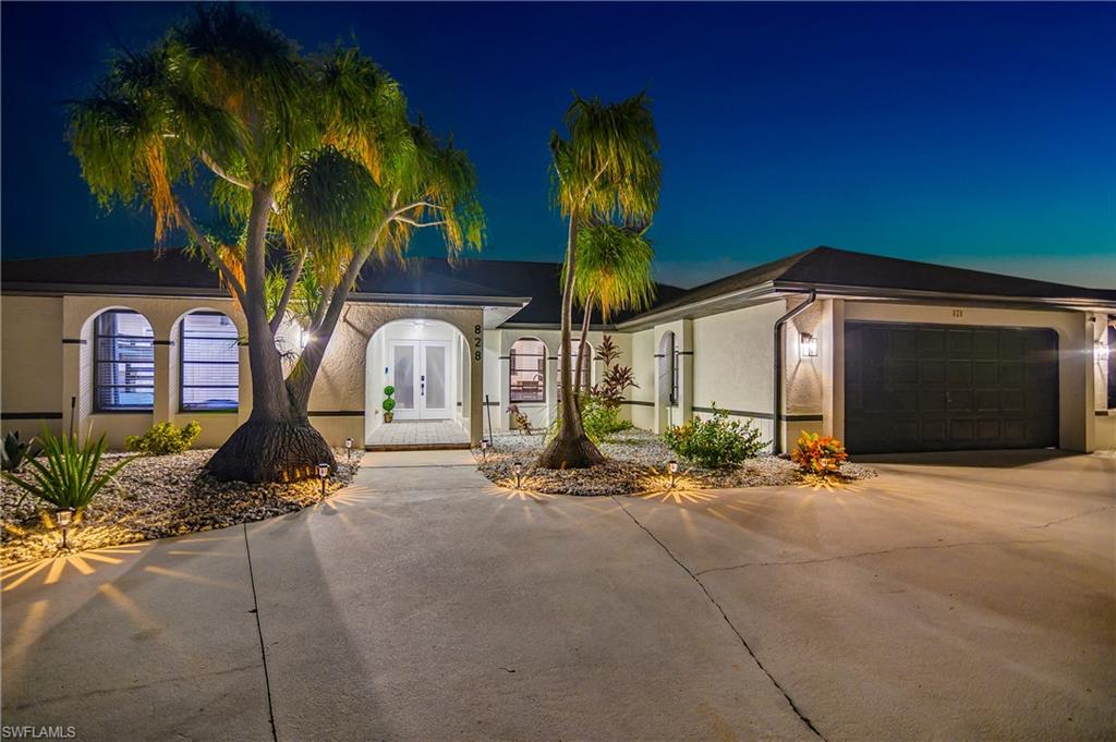 Exterior featuring a concrete driveway, two-car garage, and arched entryways