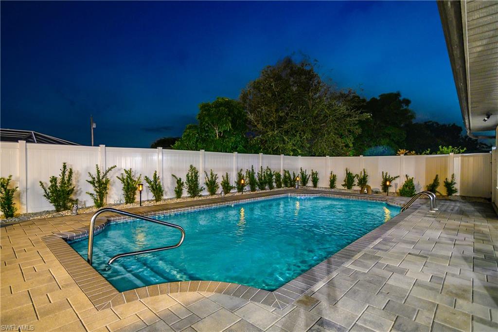 Rectangular swimming pool featuring integrated steps and dual handrails