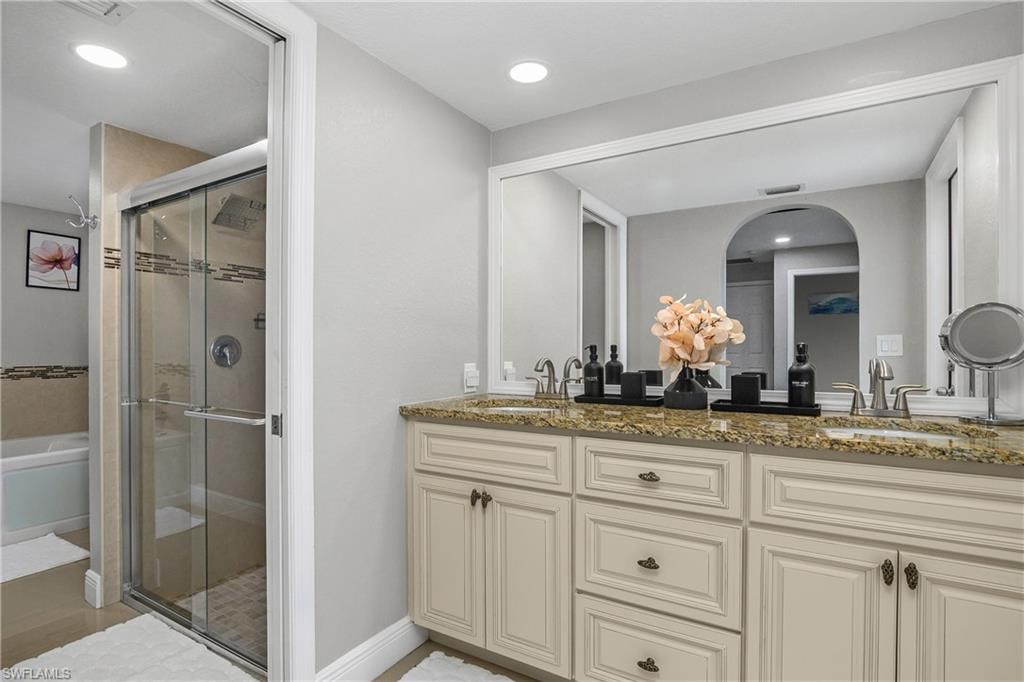 Double vanity with a speckled countertop, undermount sinks, and brushed nickel faucets
