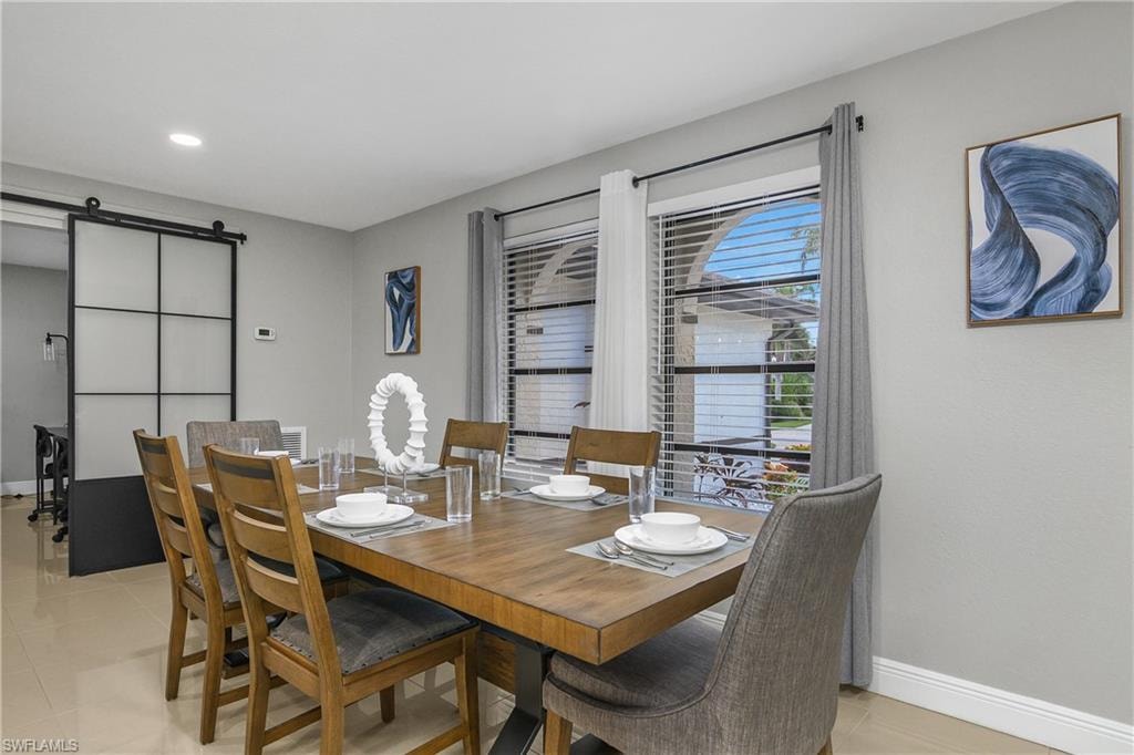 Dining area featuring a wood-finish table, recessed lighting, and tile flooring