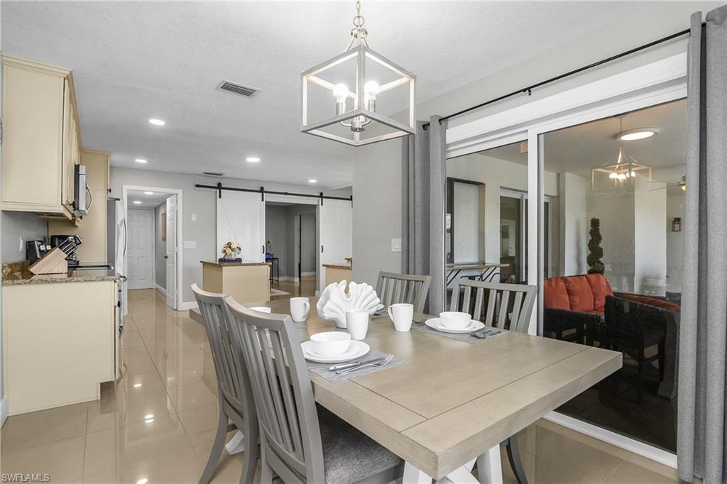 Dining area with a modern linear chandelier and ample natural light from sliding glass doors