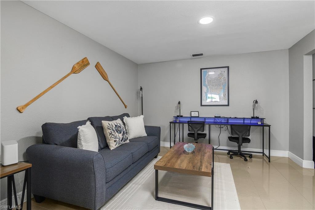 Living area with light gray wall paint and recessed ceiling lighting