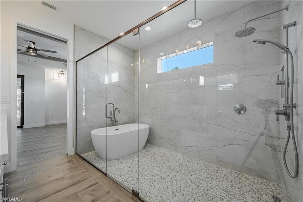Bathroom with wood-type flooring and independent shower and bath