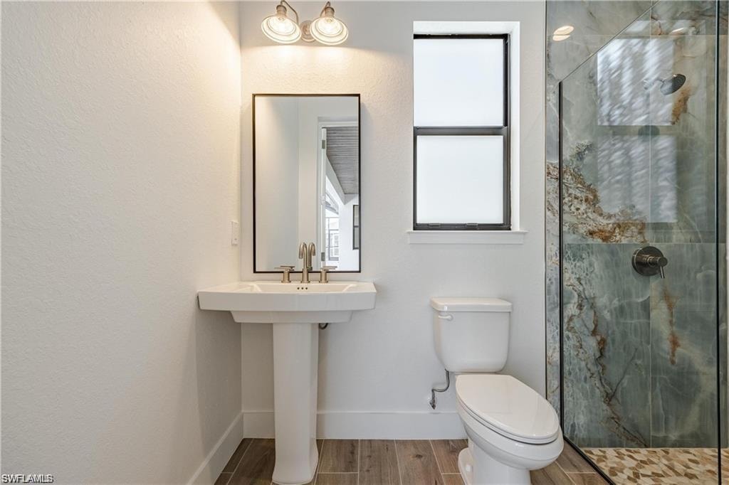 Bathroom with a shower with shower door and toilet