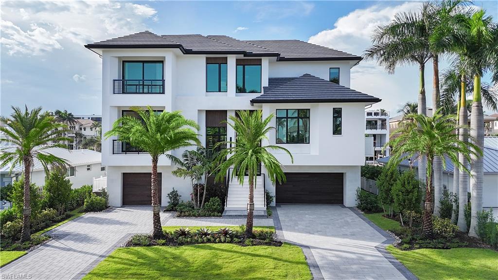 Modern architectural exterior featuring a white stucco finish and a dark tile roof