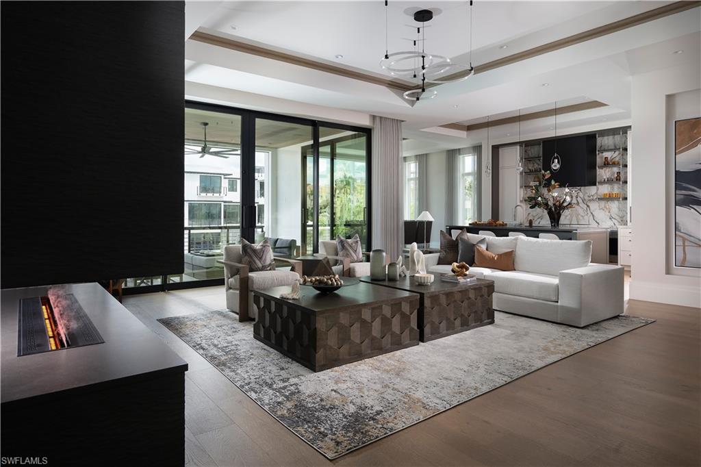 Spacious open-concept living area featuring wood-finish flooring and extensive sliding glass doors