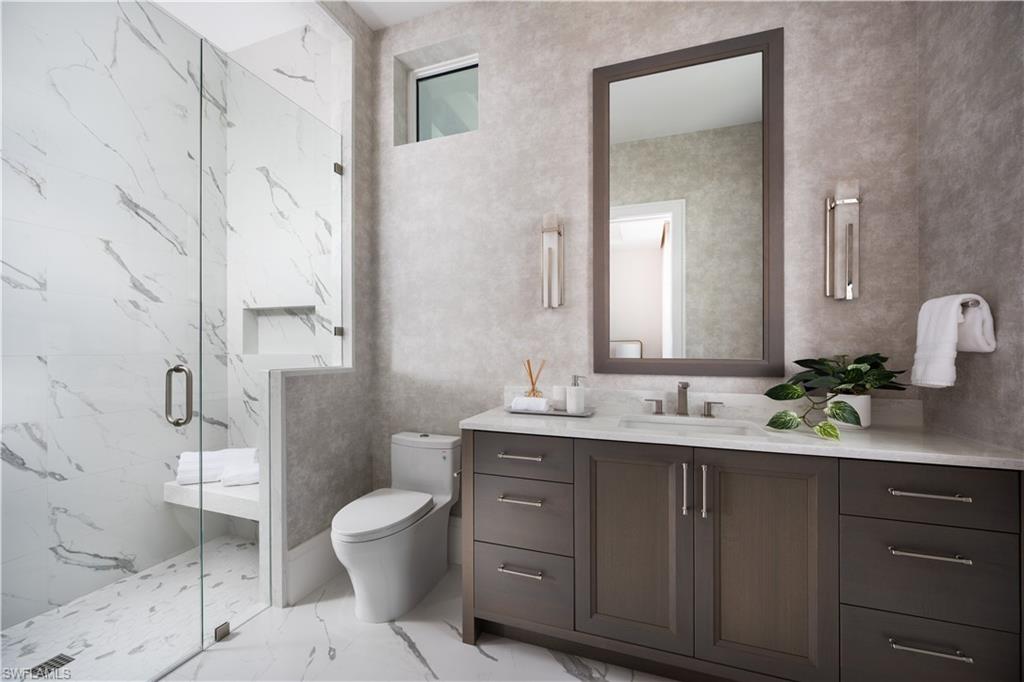 Contemporary bathroom featuring a spacious glass-enclosed shower with a built-in bench and recessed shelf