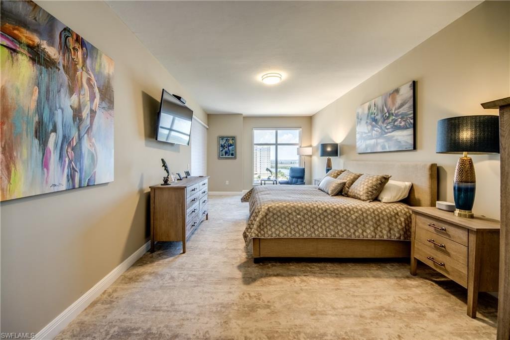Spacious master  bedroom featuring light-toned walls, patterned carpeting, and recessed lighting