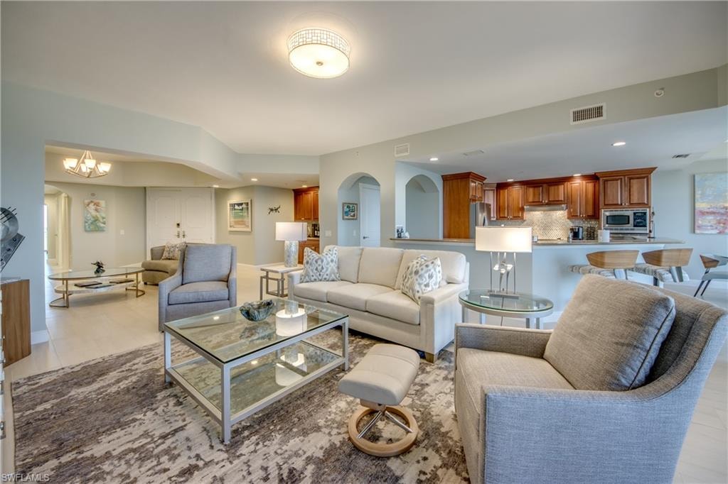 Open-concept living space featuring light flooring, recessed lighting, and a kitchen bar with pendant lighting