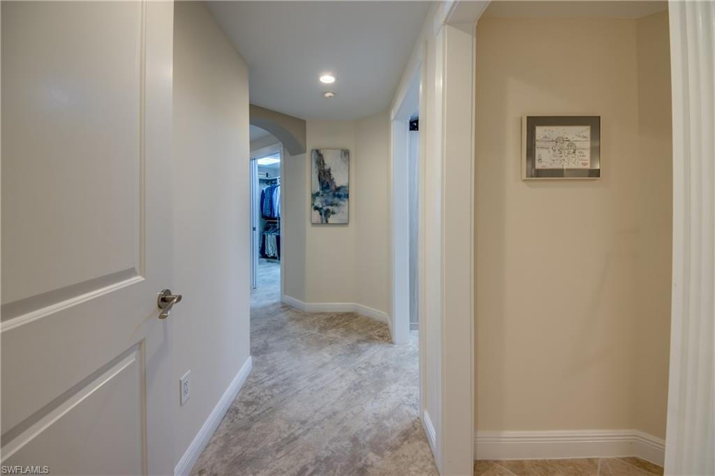 Hallway featuring recessed lighting, light-toned wall paint, and patterned carpet flooring