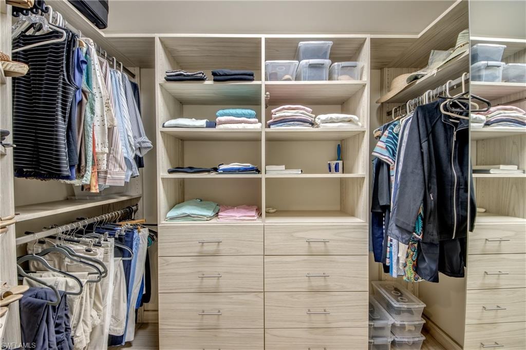 Custom closet system featuring light wood-finish cabinetry