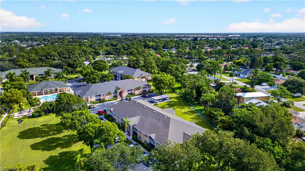 Expansive aerial showcasing a community of multi-story residential buildings with tan exteriors and dark roofing