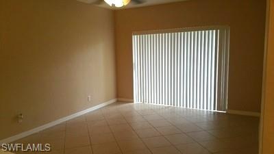 Neutral-toned wall finishes, tiled flooring, vertical window blinds, and overhead ceiling fan